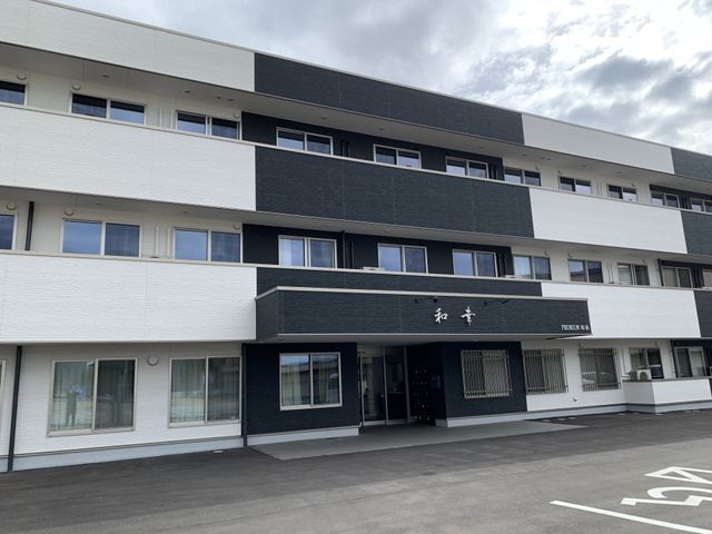 清潔感のある施設外観 外観 広々とした前庭が印象的な白と黒の建物です。入口の様子からもアクセシビリティへの配慮が感じられます。
