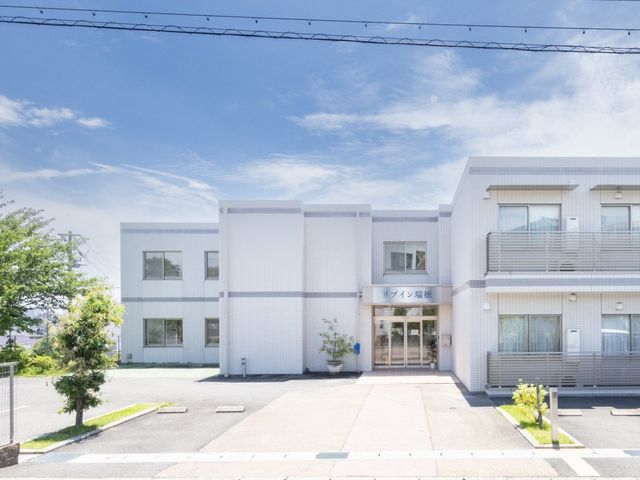 笑顔あふれるスタッフイメージ 外観 明るい笑顔で対話するスタッフと入居者の姿から、暖かな職場の雰囲気が伝わります。