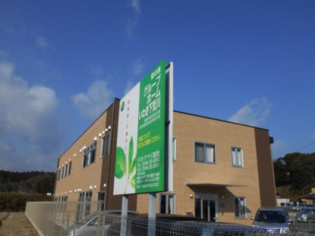 緑の看板がある建物外観 外観 緑豊かな看板が目印の明るい建物です。自然に囲まれた環境で働くことができます。