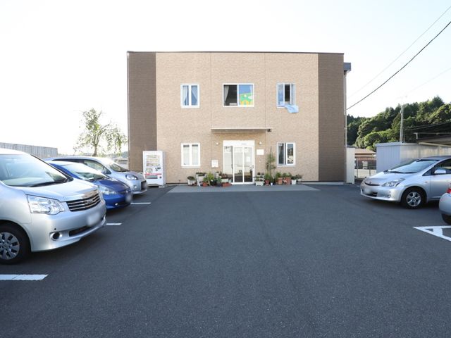 入口付近の駐車場 外観 駐車スペースが確保された清潔な外観です。利用者の方々が安心して訪れることができる明るい環境が整っています。