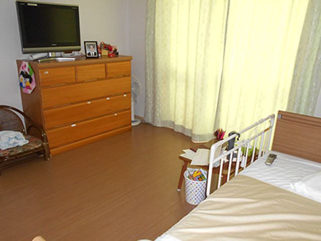 明るい居室 居室 自然光が差し込む居室で、仕事に集中できる環境です。家具が配置され、生活感があります。