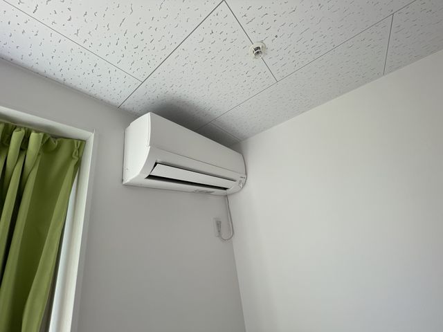 清潔感のあるエアコン エアコン 部屋に備え付けられたエアコンは清潔感があり、快適な気温を保つのに役立ちます。