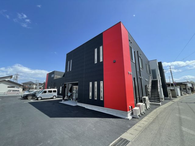 赤と黒のモダンな外観 外観 赤と黒でデザインされた施設の彩りが印象的です。広々とした駐車スペースが確保されています。