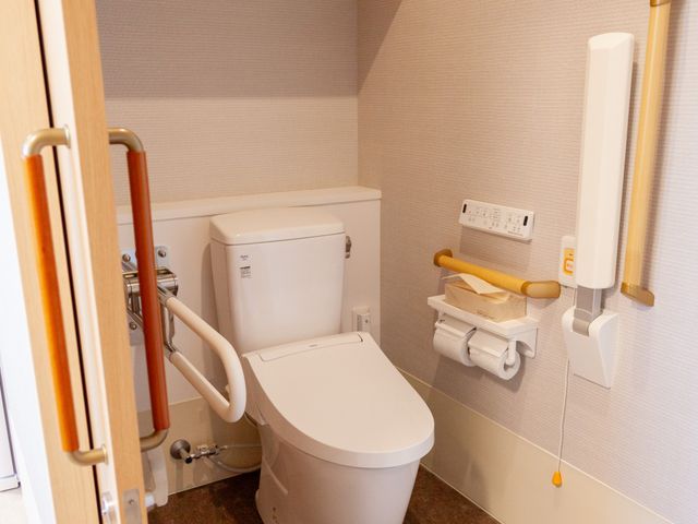 快適なトイレ空間 トイレ 手すりが備わった清潔なトイレです。安心してご使用いただける環境が整っています。