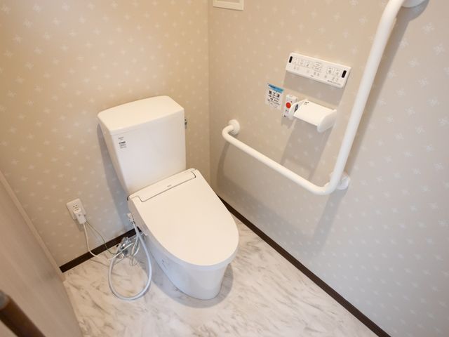 バリアフリー対応のトイレ トイレ 手すりが取り付けられた清潔感のあるトイレです。安全かつ快適にご利用いただける設計となっています。