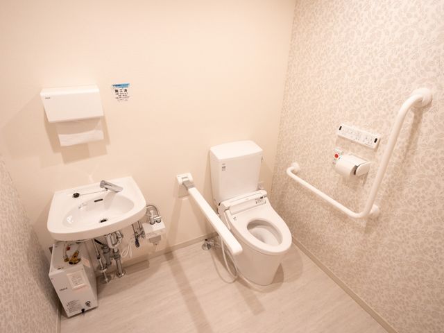 バリアフリー設計のトイレ トイレ 手すりが設置された清潔感のあるトイレ空間です。安心してご利用いただける配慮がされています。