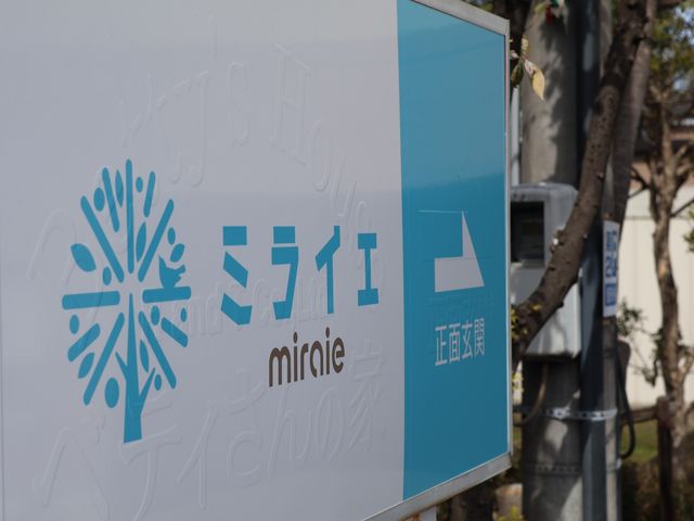 スタッフ募集の施設看板 看板 新しい仲間を待つ、心地よい環境を象徴する看板の前で、あなたのキャリアをスタートさせませんか。