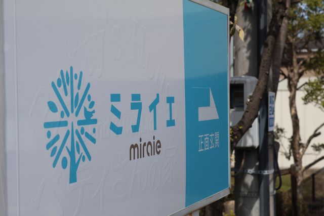 スタッフ募集の施設看板 看板 新しい仲間を待つ、心地よい環境を象徴する看板の前で、あなたのキャリアをスタートさせませんか。
