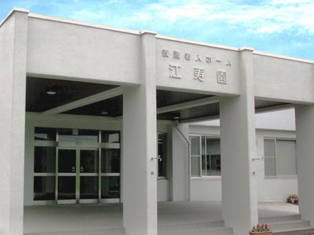 施設の正面玄関 外観   白い外壁と大きな庇が印象的な出入口です。車での送迎時も建物前まで近づきやすそうです。