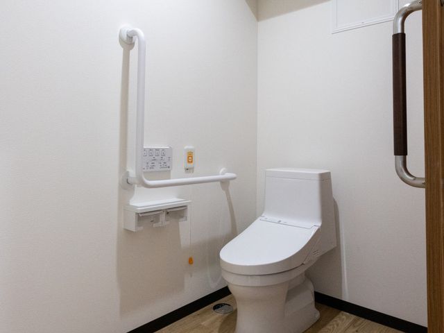 安全な配慮があるトイレ トイレ 手すりが備えられた広めの空間で、安心して利用できる設備が整っています。