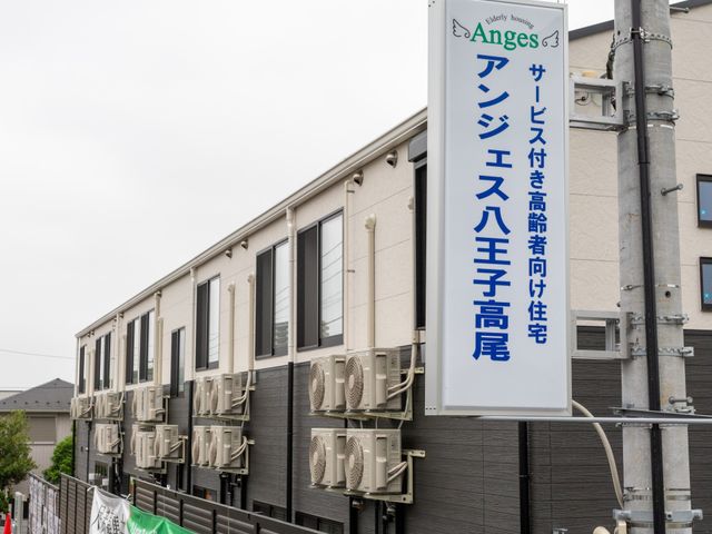 大きな建物の看板 看板 通りに面した角に、施設の名前が掲げられた看板があります。