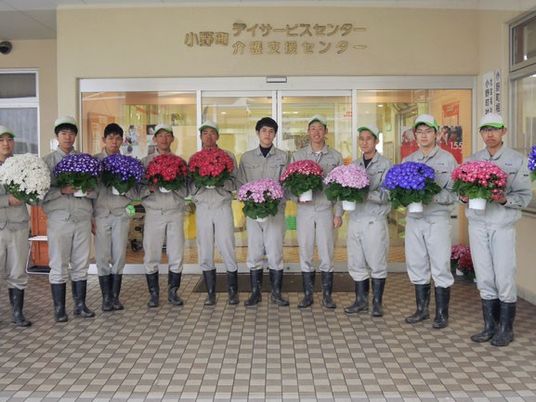 花を持つスタッフと玄関  