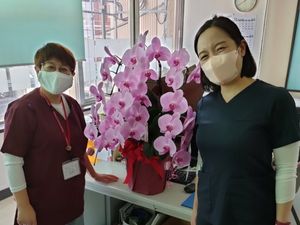 職員2人と受付の花飾り  