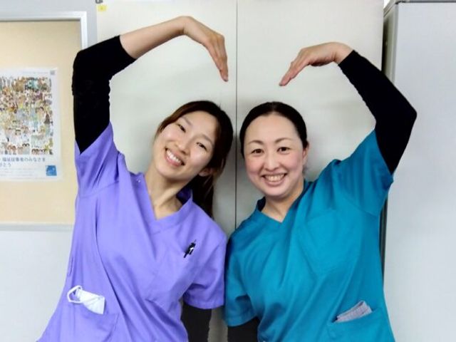 仕事着姿の女性二人 スタッフイメージ 笑顔でポーズを取るスタッフの方々が、明るく温かな雰囲気を醸し出しています。