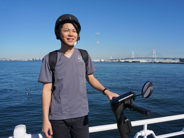 スタッフイメージ 笑顔のスタッフが立っている様子です。清潔感ある制服を着用し、気持ちの良い接客が期待できます。