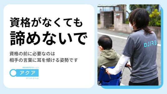 屋外で車椅子を支えるスタッフ  