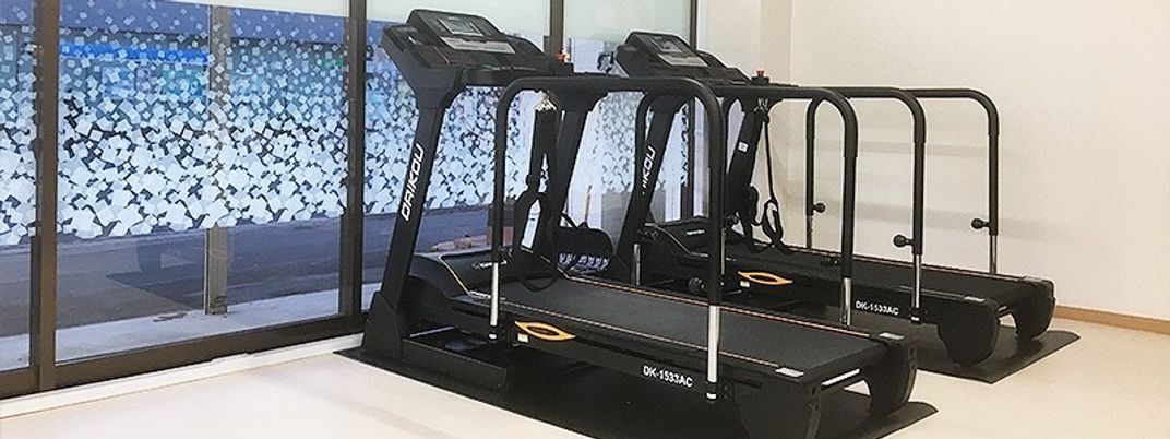 窓辺に並んだトレッドミルの機能訓練室  