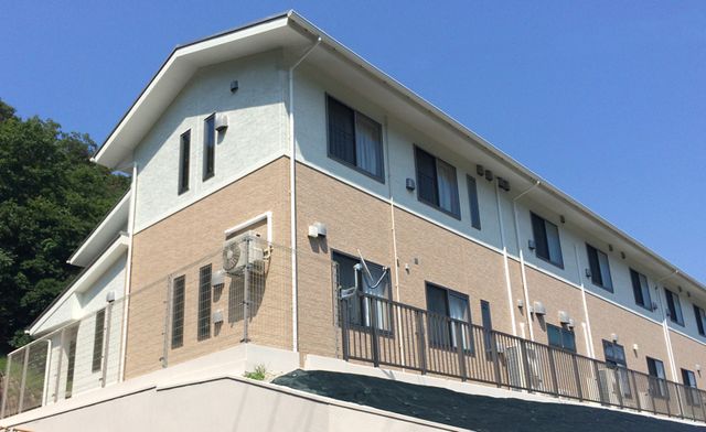 広い二階建ての建物 外観 シンプルな二階建ての建物で働く環境をイメージしやすいです。青空の下で明るい印象です。