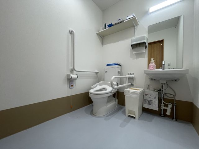 手すり付きのトイレ トイレ 手すりが設置されたトイレです。介助が必要な方も安心して利用できる設計になっています。