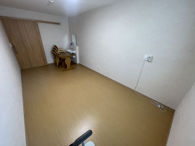 居室の空間 居室 広々とした居室で、木目調の床が温かみを感じさせます。シンプルなインテリアが特徴です。