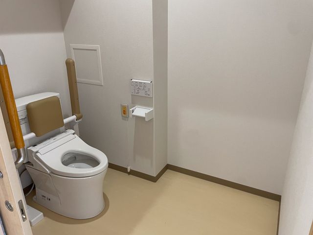 手すり付きの洋式トイレ トイレ バリアフリー設計の明るいトイレです。手すりが設置され、使いやすさに配慮されています。