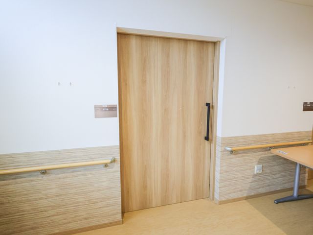 出入口の扉 廊下 安全に配慮された手すりが設置された廊下は、安心して通行することができます。出入口は木製の引き戸で開閉も簡単です。