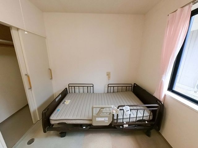 ベッドがある部屋 居室 自然光が差し込む居室です。車椅子でも出入りしやすいように、ドアの幅が広めになっています。