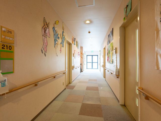 明るい廊下 廊下 手すり付きの廊下です。温かみのある壁絵が、利用者の方へリラックスを提供します。