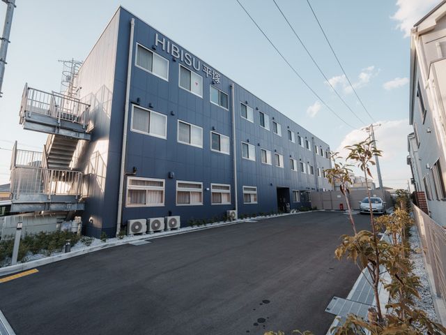 青い外観の建物 外観 清潔感のある青い外観が印象的な建物です。広々としたエントランスへと続いています。