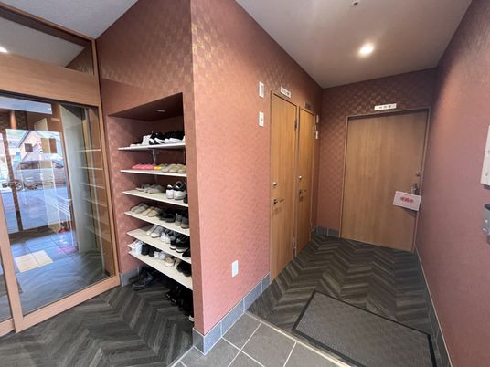 木製ドアと靴棚のある廊下