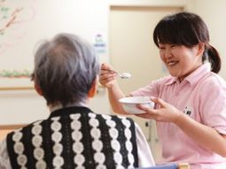 笑顔で食事介助するスタッフ