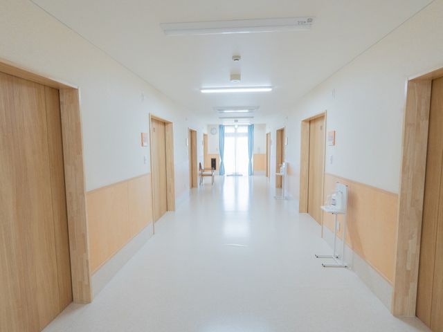 明るい廊下 廊下 自然光が差し込む明るい廊下です。木製の扉が温かみを感じさせ、清潔感があります。