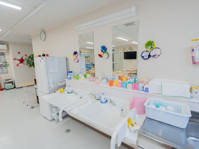 洗面台と備品が置かれた室内 洗面台 明るい空間に、使いやすく配置された洗面台と備品が揃っています。清潔で機能的な環境です。