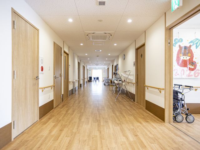 長い廊下 廊下 広々とした廊下があり、車椅子を利用しても快適に移動できる設計です。ナチュラルな色調の内装が落ち着いた雰囲気を醸し出しています。