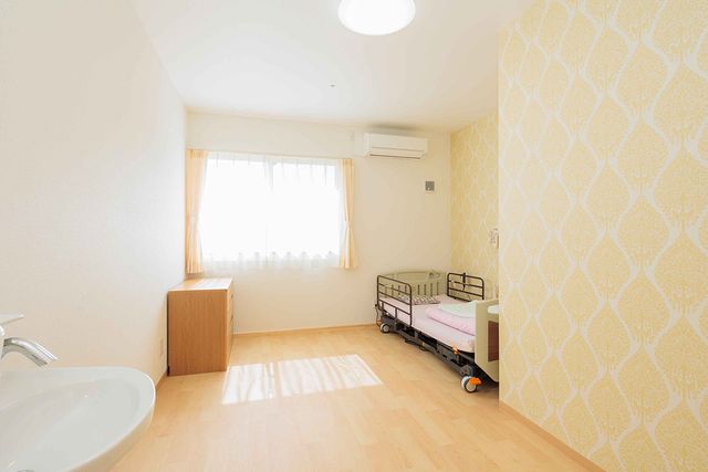 ナチュラル光の居室 居室 自然光が差し込む明るい空間の居室です。ベッドや家具がシンプルに配置されています。