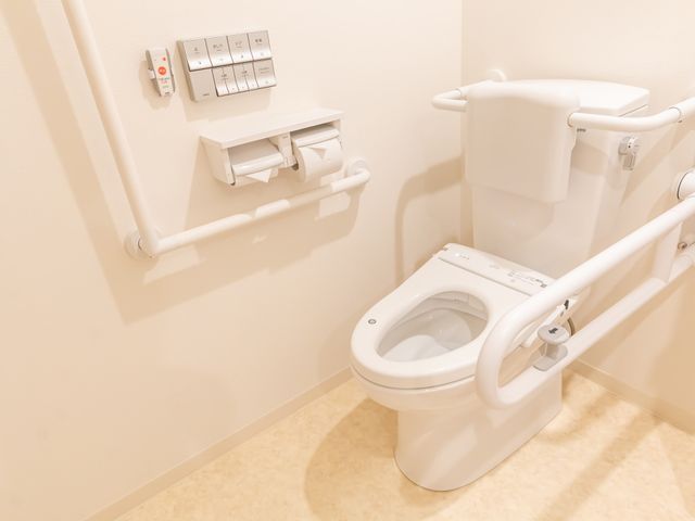 手すり付きの安全なトイレ トイレ 手すりが設置され、安全性に配慮した清潔な空間。ご安心してお使いいただける設備が整っています。