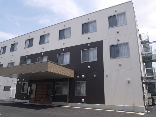 清潔な外観の建物 外観 落ち着いた色合いの外観で、清潔感があります。ゆったりとした入り口が、皆様を暖かくお迎えします。