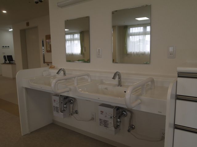 利用者向け洗面台 洗面台 手すり付きの洗面台は安全性を考え、バリアフリーに配慮されています。清潔感があり、利用者の快適な日常生活を支えます。