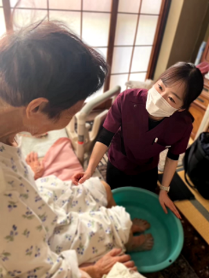 足湯を受ける高齢者とスタッフ
