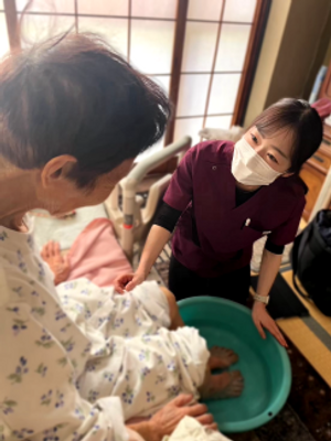 足湯を受ける高齢者とスタッフ