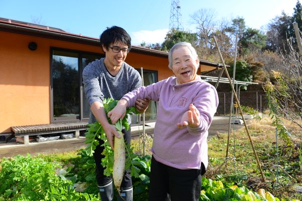 笑顔で野菜収穫する二人