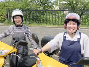 笑顔のスタッフがバイクに乗る外観  