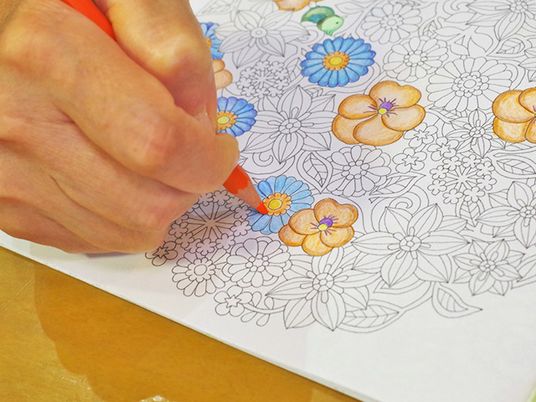 花柄の塗り絵をする手