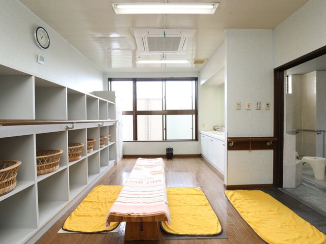 明るい和室 脱衣所 床にはたたみが敷かれ、ここで静かな時間を過ごす様子が想像されます。収納には籠が整然と並べられ、秩序だった空間が保たれています。