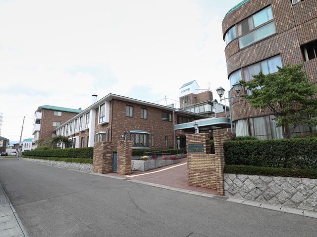 外観の建物と入口 外観 広々とした前庭には植物があり、落ち着いた雰囲気のあるエントランスがお出迎えします。明るく開放的な環境で、新しい職場をご検討ください。