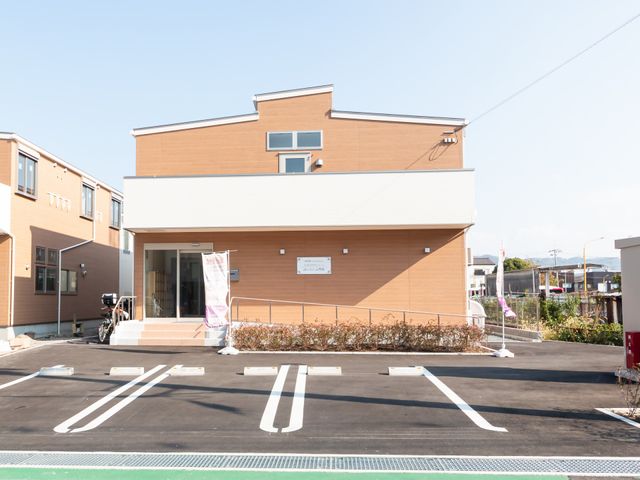 自転車が停まる建物外観 外観 駐輪スペースが整備されており、通勤にも便利な環境です。明るい色合いの建物が魅力的です。