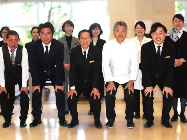 職員が集まるロビー ロビー 明るいロビーで、職員が和やかに集合しています。チームワークが大切な職場の雰囲気が伝わります。