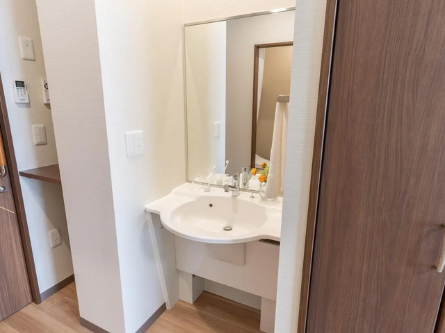 モデルルーム洗面台 お部屋には、毎日の身だしなみを整えやすいよう、大きな鏡付きの洗面台を設置。車いすの方でも使いやす
いよう、足元にはスペースを空けております。