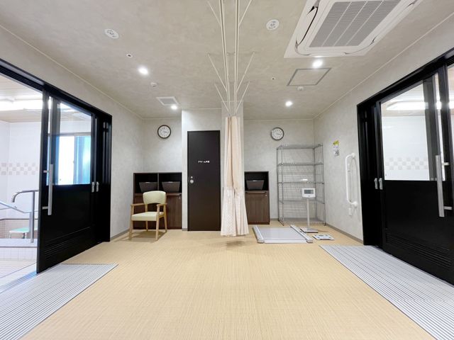 機能訓練室 脱衣所 広々とした空間で、身体を動かしやすい工夫が施されています。リハビリの器具も備え付けられています。