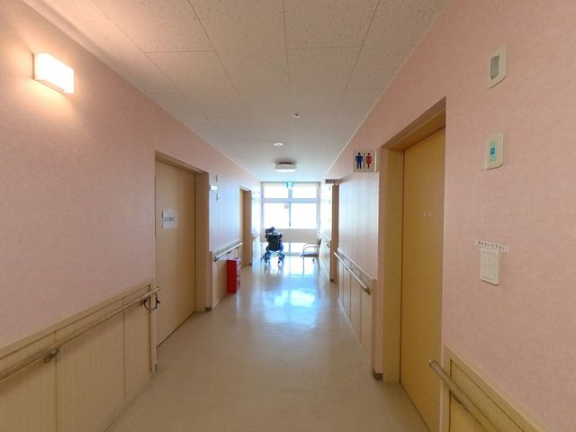 廊下にいる方々 廊下 温かみのある照明が印象的な廊下です。手すりがついていて、安心して歩ける設計になっています。